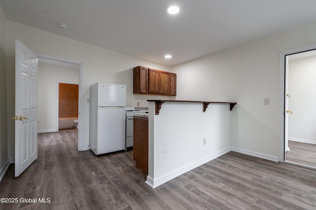 128 Circular St, Saratoga Springs, NY 12866 - kitchen featuring white appliances, dark wood finished floors, a peninsula, a breakfast bar area, and recessed lighting