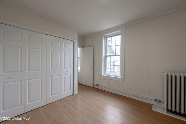 128 Circular St, Saratoga Springs, NY 12866 - unfurnished bedroom with radiator, light wood-type flooring, a closet, and ornamental molding
