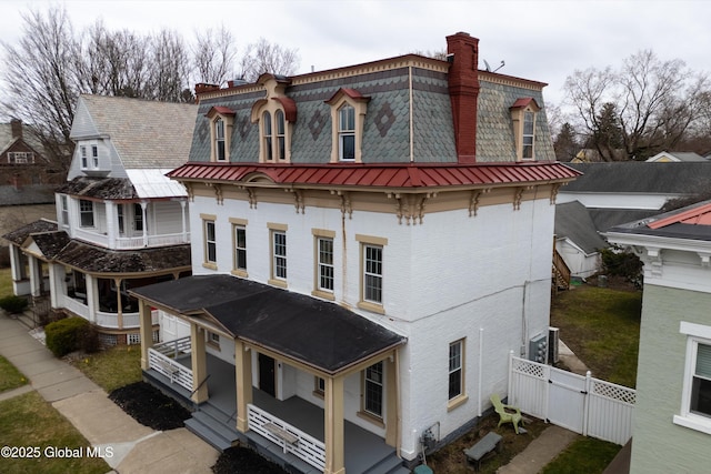 128 Circular St, Saratoga Springs, NY 12866 - back of property with a chimney, a gate, mansard roof, brick siding, and a high end roof