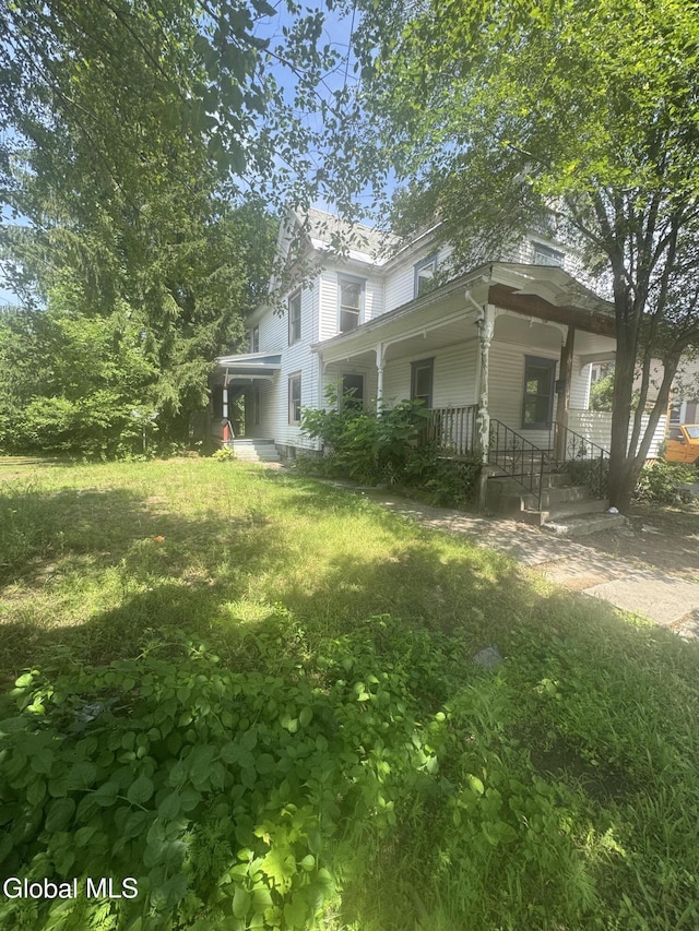 183 Main St, South Glens Falls, NY 12803 - view of side of home with a porch and a lawn