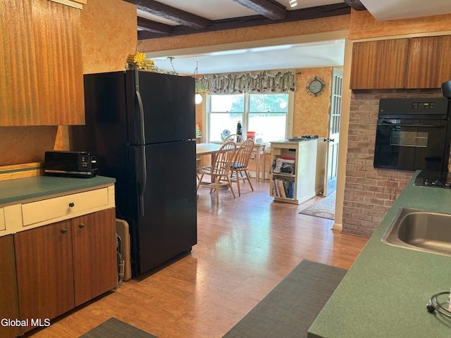 576 County Highway 102, Gloversville, NY 12078 - kitchen with light wood-style floors, black appliances, brown cabinets, and beamed ceiling