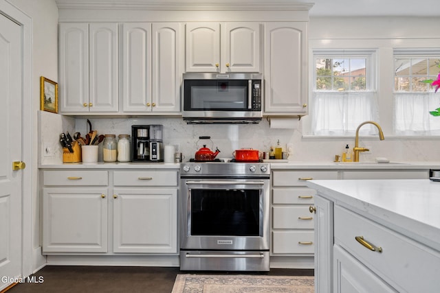 1556 Wendell Ave, Schenectady, NY 12308 - kitchen with appliances with stainless steel finishes, light countertops, backsplash, and white cabinetry