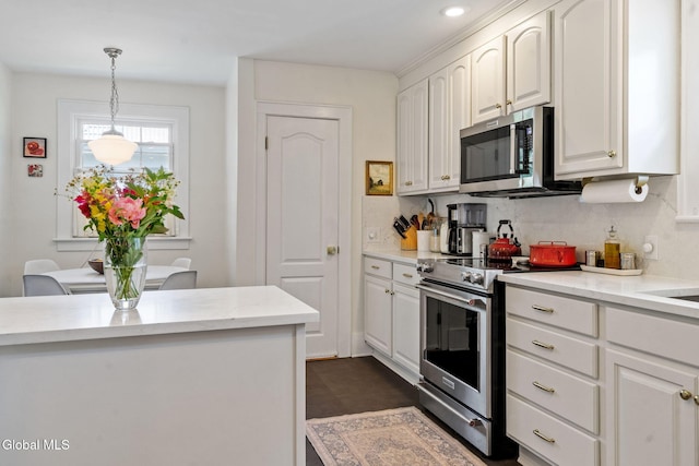 1556 Wendell Ave, Schenectady, NY 12308 - kitchen featuring appliances with stainless steel finishes, backsplash, white cabinets, and hanging light fixtures
