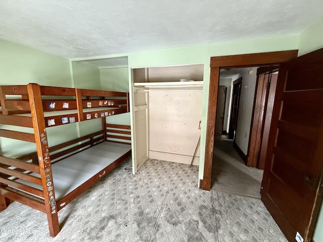 74 Park St, Gloversville, NY 12078 - unfurnished bedroom featuring a textured ceiling, carpet flooring, and a closet