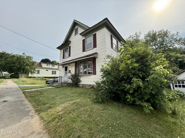74 Park St, Gloversville, NY 12078 - view of front facade with a front lawn