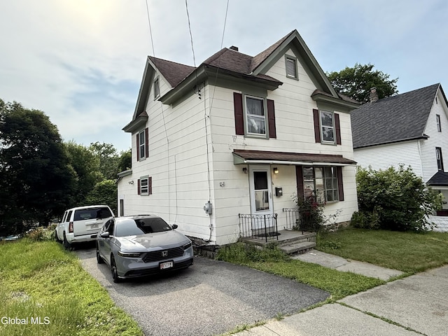 74 Park St, Gloversville, NY 12078 - traditional home featuring a front lawn, a shingled roof, and driveway