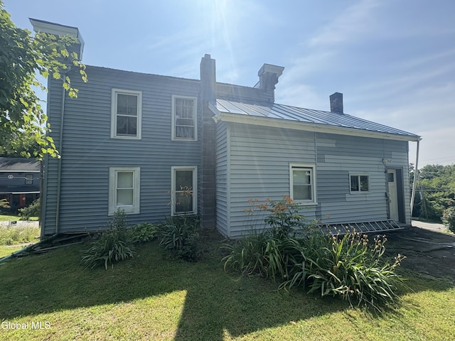 5 Spring St, Port Henry, NY 12974 - back of property with a metal roof, a yard, a chimney, and a standing seam roof