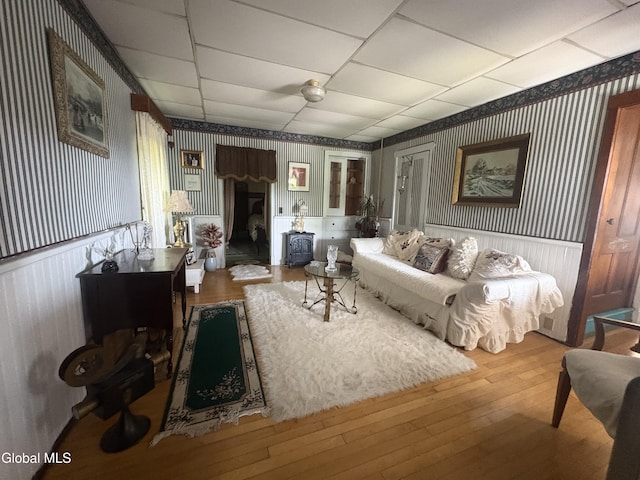 5 Spring St, Port Henry, NY 12974 - living area featuring wallpapered walls, wood-type flooring, a paneled ceiling, and wainscoting