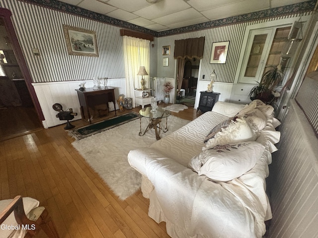 5 Spring St, Port Henry, NY 12974 - living room featuring wallpapered walls, wood-type flooring, a drop ceiling, and a wood stove