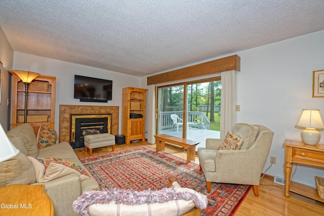 35 Warwick Way, Niskayuna, NY 12309 - living area with a textured ceiling, wood finished floors, and a tile fireplace