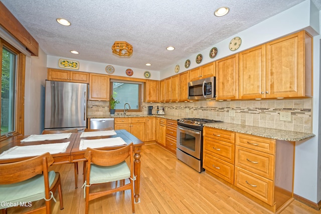 35 Warwick Way, Niskayuna, NY 12309 - kitchen with stainless steel appliances, a textured ceiling, healthy amount of natural light, tasteful backsplash, and light wood-style flooring