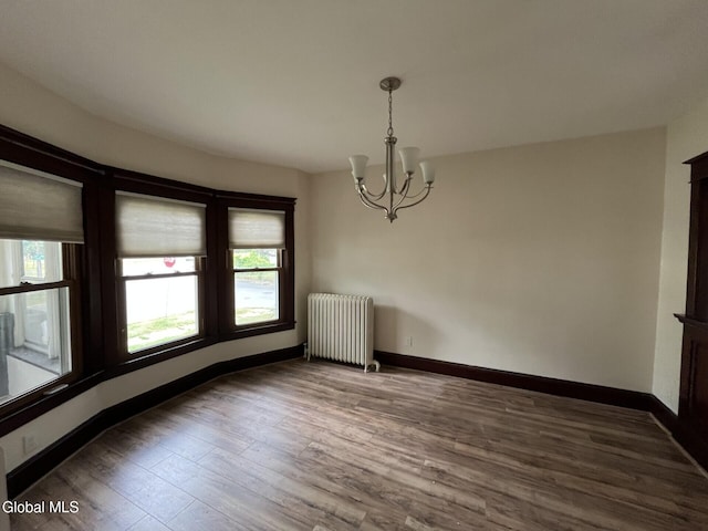 1822 7th St, Rensselaer, NY 12144 - spare room with radiator, a chandelier, and wood finished floors