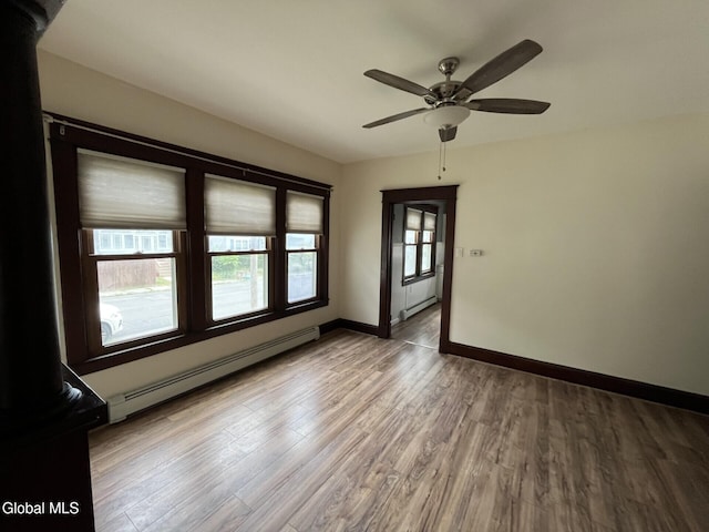 1822 7th St, Rensselaer, NY 12144 - empty room featuring baseboard heating, wood finished floors, and a ceiling fan