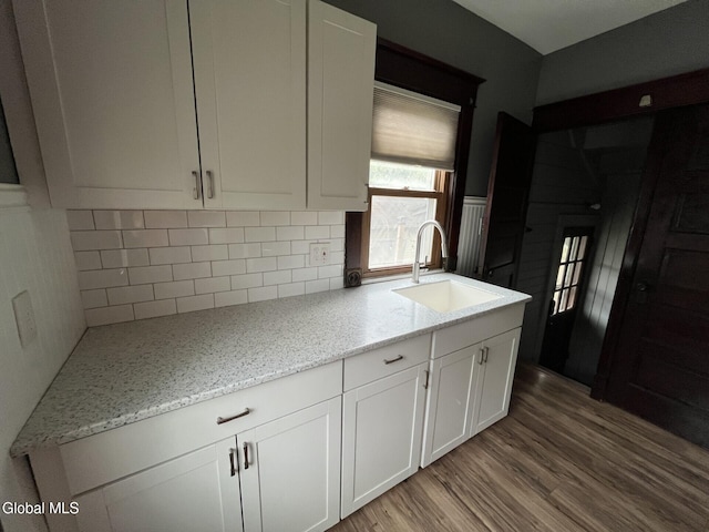 1822 7th St, Rensselaer, NY 12144 - kitchen with light wood-style floors, white cabinetry, backsplash, and light stone counters
