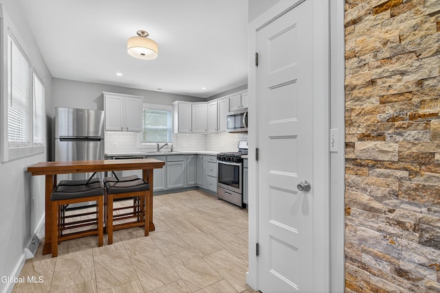 55 Crescent Ave, Saratoga Springs, NY 12866 - kitchen featuring backsplash, stainless steel appliances, gray cabinetry, light countertops, and recessed lighting