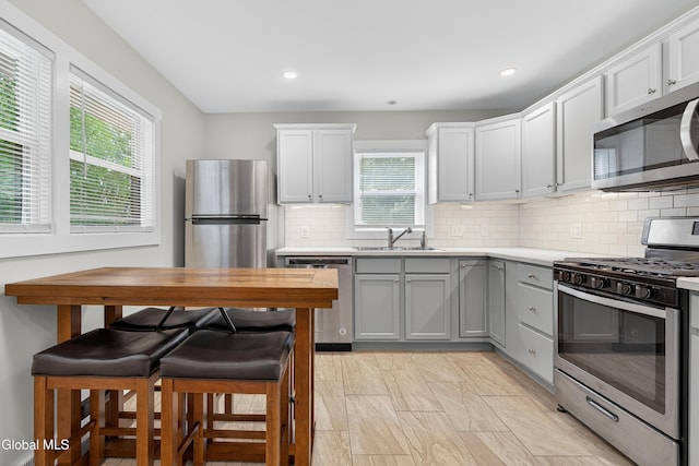55 Crescent Ave, Saratoga Springs, NY 12866 - kitchen featuring stainless steel appliances, gray cabinets, light countertops, decorative backsplash, and recessed lighting