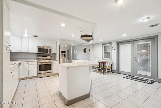420 Caverns Rd, Cobleskill, NY 12092 - kitchen featuring appliances with stainless steel finishes, french doors, a center island, white cabinetry, and recessed lighting