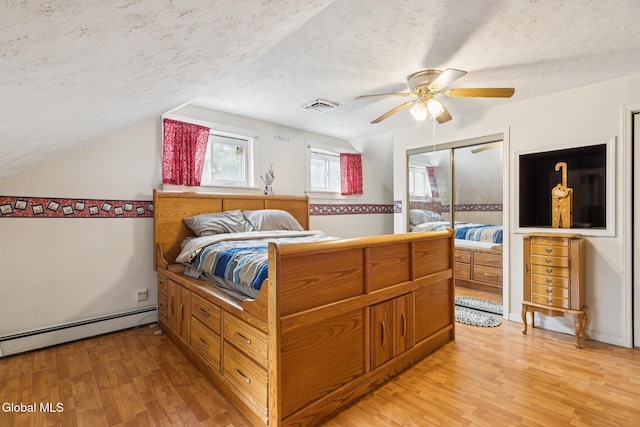 420 Caverns Rd, Cobleskill, NY 12092 - bedroom featuring a textured ceiling, vaulted ceiling, light wood-style flooring, baseboard heating, and ceiling fan