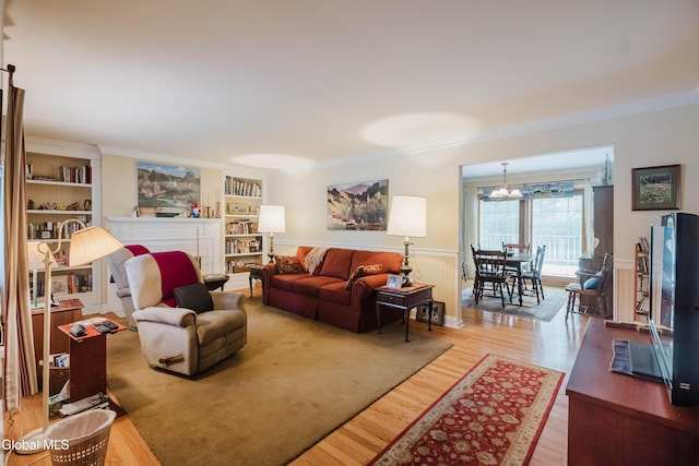 19 Drawbridge Dr, Guilderland, NY 12203 - living room with ornamental molding, wood finished floors, a chandelier, a wainscoted wall, and built in features