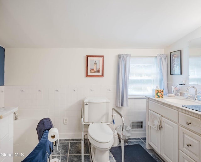19 Drawbridge Dr, Guilderland, NY 12203 - bathroom featuring tile walls, a bath, vanity, tile patterned floors, and a wainscoted wall