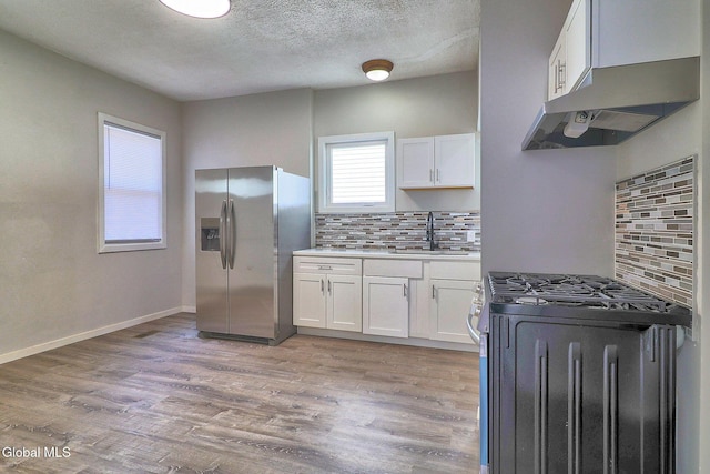 421 Summit Ave, Schenectady, NY 12307 - kitchen with stainless steel refrigerator with ice dispenser, gas range, decorative backsplash, under cabinet range hood, and white cabinets