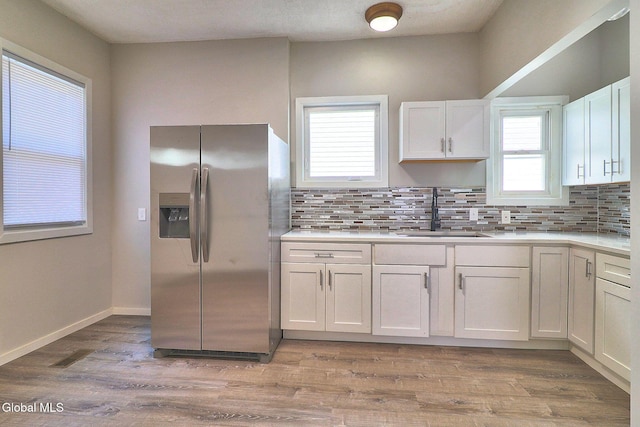 421 Summit Ave, Schenectady, NY 12307 - kitchen featuring stainless steel fridge, white cabinets, backsplash, and healthy amount of natural light