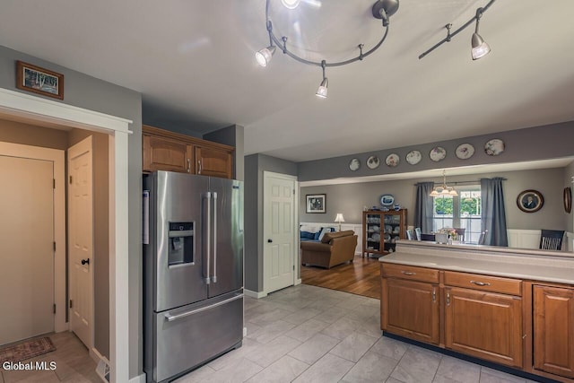 54 S Whitney Rd, Stillwater, NY 12866 - kitchen with stainless steel refrigerator with ice dispenser, light countertops, brown cabinets, open floor plan, and rail lighting