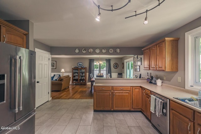 54 S Whitney Rd, Stillwater, NY 12866 - kitchen featuring appliances with stainless steel finishes, a peninsula, light countertops, brown cabinets, and open floor plan