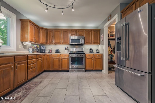 54 S Whitney Rd, Stillwater, NY 12866 - kitchen with appliances with stainless steel finishes, brown cabinetry, light countertops, and light tile patterned flooring