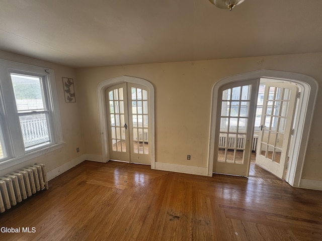 261 Altamont Ave, Schenectady, NY 12304 - unfurnished room with french doors, arched walkways, radiator, and wood finished floors