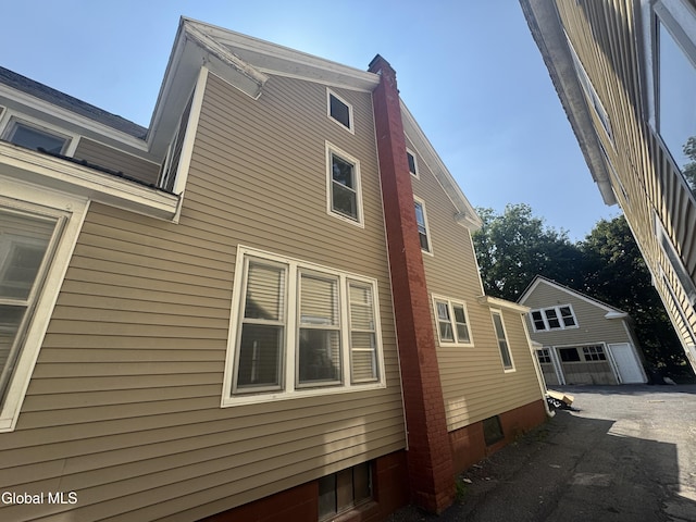 261 Altamont Ave, Schenectady, NY 12304 - view of home's exterior with a detached garage, a chimney, and an outbuilding