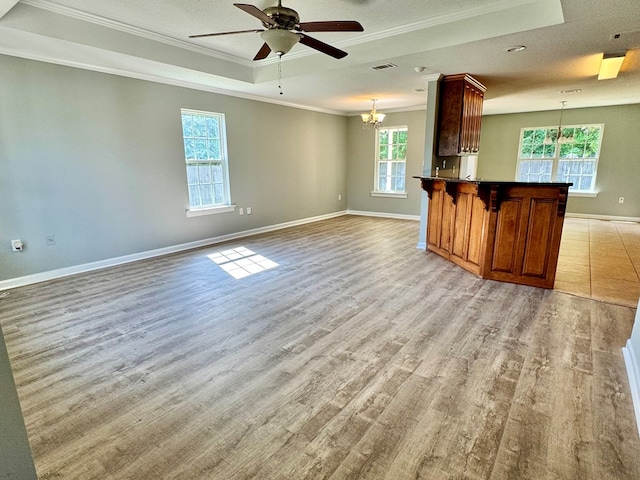 5341 Branch Pt, Valdosta, GA 31605 - unfurnished living room with ornamental molding, ceiling fan, plenty of natural light, light wood finished floors, and a tray ceiling