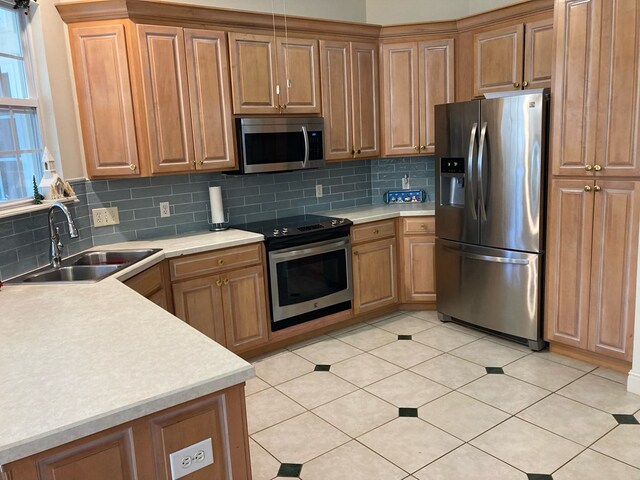 kitchen featuring light tile patterned flooring, appliances with stainless steel finishes, backsplash, and sink