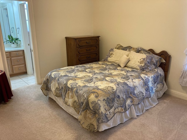 bedroom featuring light colored carpet and connected bathroom