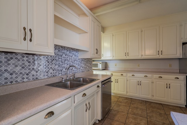 kitchen featuring white cabinets, stainless steel dishwasher, dark tile patterned floors, and sink