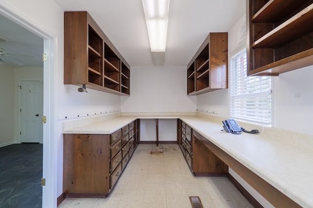 kitchen with ceiling fan and dark brown cabinetry