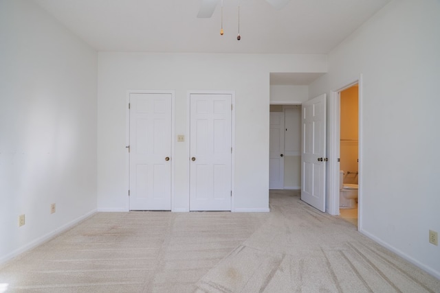 unfurnished bedroom with ensuite bathroom, ceiling fan, and light colored carpet