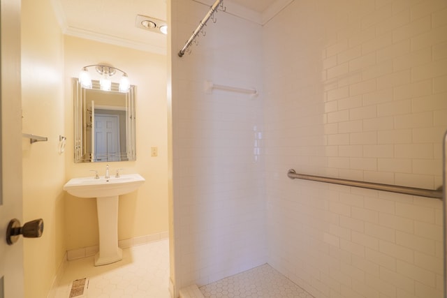 bathroom featuring tile patterned flooring, a tile shower, and ornamental molding