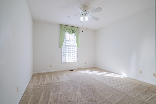 carpeted empty room featuring a textured ceiling and ceiling fan