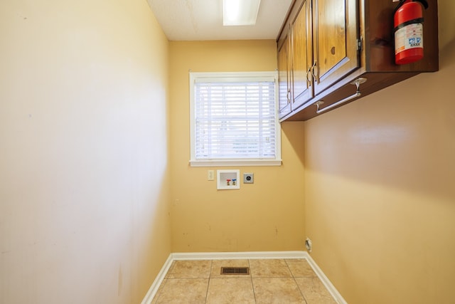 laundry area with cabinets, hookup for a washing machine, light tile patterned floors, and electric dryer hookup