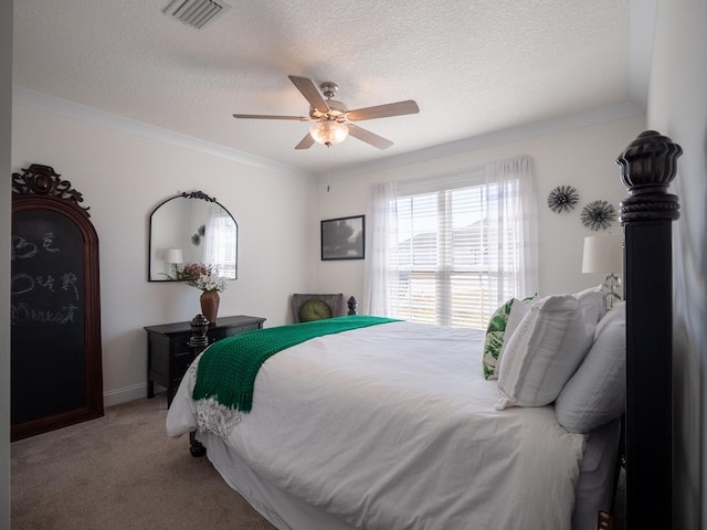 bedroom featuring light colored carpet, visible vents, a ceiling fan, ornamental molding, and a textured ceiling