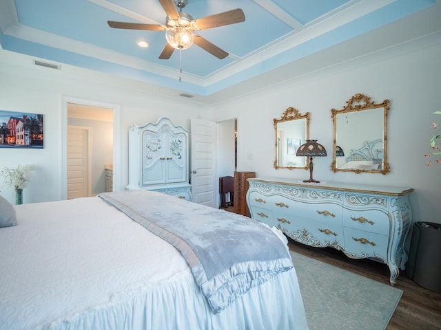 bedroom featuring visible vents, a raised ceiling, dark wood finished floors, ceiling fan, and crown molding