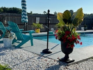 community pool with a patio area and fence