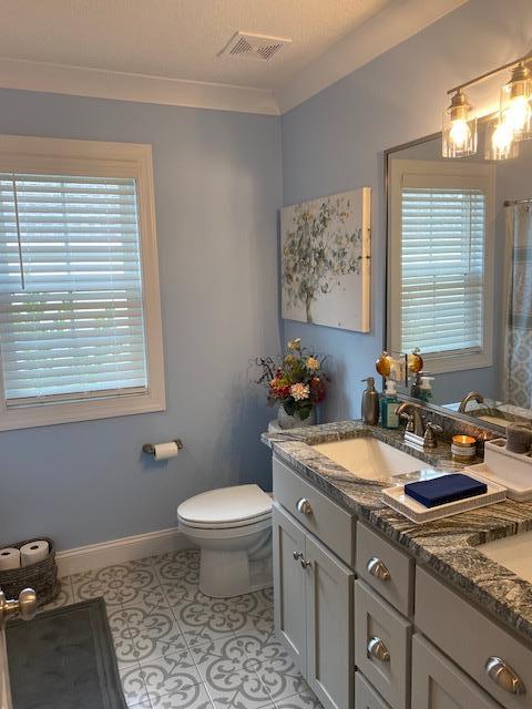 full bathroom with tile patterned flooring, toilet, a sink, visible vents, and baseboards