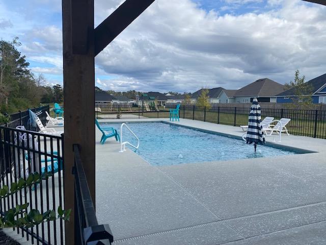 pool with a patio area and fence