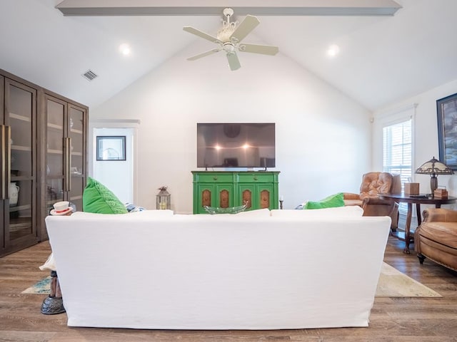 living room featuring high vaulted ceiling, beam ceiling, wood finished floors, and visible vents