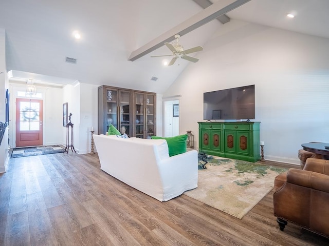 living area featuring visible vents, wood finished floors, high vaulted ceiling, beamed ceiling, and baseboards