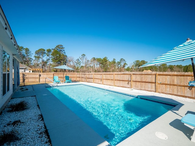 view of swimming pool with a fenced in pool, a fenced backyard, and a patio