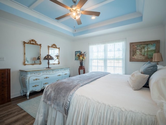 bedroom featuring ceiling fan, ornamental molding, a raised ceiling, and dark wood finished floors