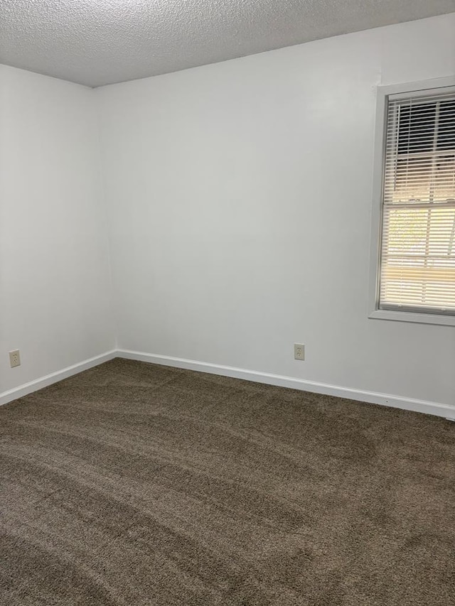 carpeted spare room with a textured ceiling